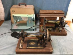 A 50s cased Singer electric sewing machine; an oak cased Edwardian hand-cranked Singer tabletop