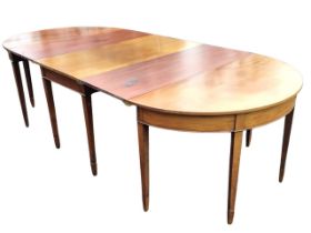 A Georgian mahogany three-section D-end dining table with two extra leaves, the tops above plain