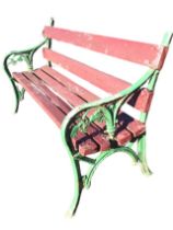 A Victorian cast iron garden bench with slatted back and seat, the ends cast with leaf decoration