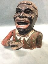 An American cast iron mechanical money box in the form of a jolly man with lever operated coin