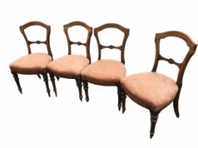 A set of four Victorian oak dining chairs with shield shaped arched backs and joining rails carved