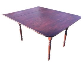 A stained pine dining table, the shaped top raised on turned tapering legs. (44in x 54.5in x 30.