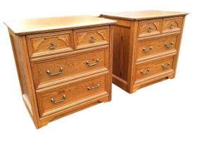 A pair of oak chests of drawers, the moulded rectangular tops above two short drawers with