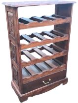 A carved mahogany wine rack, the shaped rectangular top with vines above four bottle racks and a