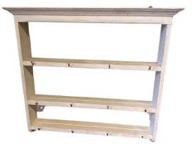 A painted hanging rack with moulded ogee cornice above three shelves with plate grooves, the