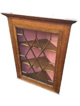 An Edwardian Hellas Ltd oak corner cabinet with moulded ogee cornice above an astragal glazed door