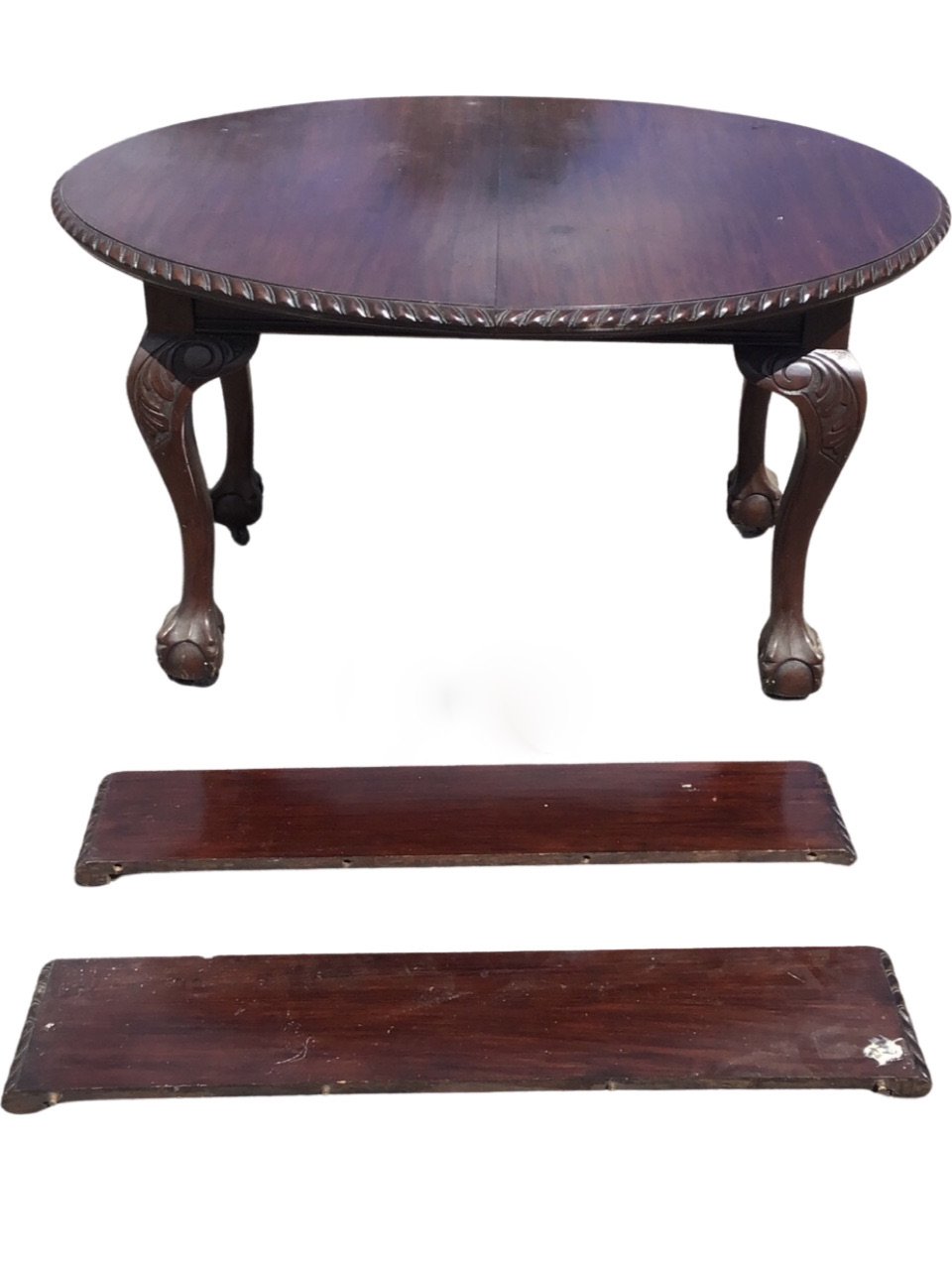 A late Victorian mahogany extending dining table with two leaves, the oval top with gadrooned edge