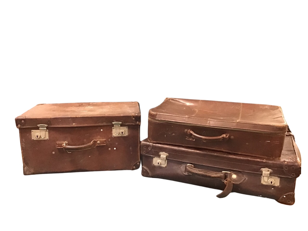 Three miscellaneous C20th leather suitcases. (3)