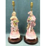 A pair of European porcelain figurines modelled as a young lady & gentlemen holding flowers, mounted