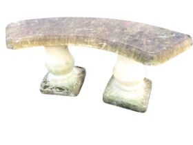 A composition stone garden bench with crescent shaped moulded seat on fluted bulbous column supports