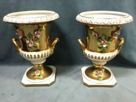 A pair of Italian classical urns of fluted form with side handles, decorated with burnished gilding,