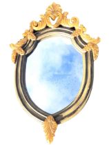 A painted shield shaped hall mirror with leaf scrolled pierced resin mounts, the frame with