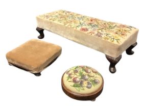 A rectangular floral needlework upholstered stool raised on stub cabriole legs with shell carved