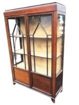 An Edwardian mahogany display cabinet, the rectangular moulded top above a plain frieze and pair