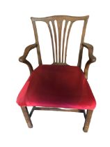 An eighteenth century mahogany elbow chair with pierced splat and shaped arms above a stuffover