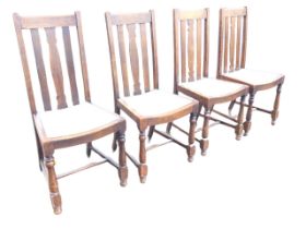 A set of four oak dining chairs, with plain slatted backs with central shaped splats, the dished