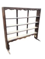 A C19th open oak delft rack, the shaped apron above four shelves, on shaped sledge feet. (55.25in