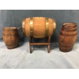 An oak and brass coopered spirit barrel on stand; an oval oak barrel with copper bands; and a