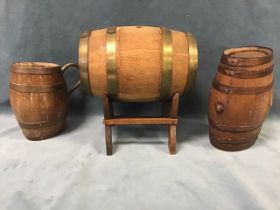 An oak and brass coopered spirit barrel on stand; an oval oak barrel with copper bands; and a