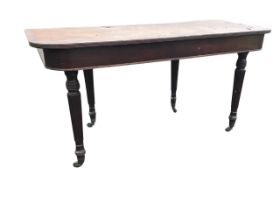 A Regency mahogany table, the rounded rectangular top and apron, raised on turned reeded legs with