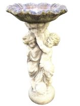 A composition stone birdbath with ripple moulded scalloped bowl on column support with twin draped