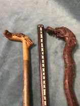 An Indonesian walking stick carved in the form of a serpent; a stick, with handle carved as a