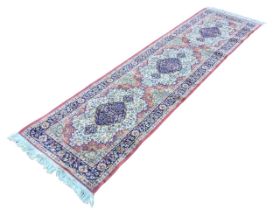 An oriental style runner woven with three scalloped medallions on mufti-floral field within a frieze