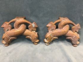 A pair of heavy antique brass feet cast in the form of entwined classical dolphins. (9.25in x 7in)