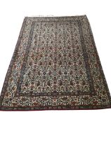 A tightly knotted Karachi rug woven with overall paisley field on ivory ground, framed by pale