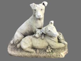 A composition stone ornamental garden group of dogs and their puppies, on naturalistically moulded