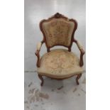 French-style open elbow salon chair with carved beech frame and needlework upholstery