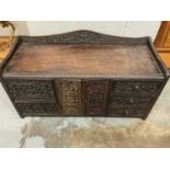 Ornate Indian carved table cabinet, with arrangement of cupboards and drawers and secret drawers, 60