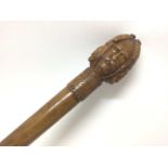 Walking cane with carved multiple face decoration to the knop