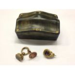 Two antique seal fobs and a gilt metal brooch, within a small green leather tooled jewellery box