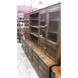 Ercol three section two height bookcase with open shelves, cupboards and glazed doors above and nume