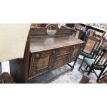 1930s Jacobean Revival carved oak sideboard, together with a set of six 1930s oak dining chairs and