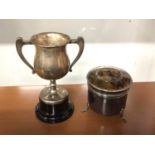 Silver two handled trophy on stand and a white metal pot with tortoishell cover