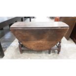 Antique oak oval drop leaf table with end drawer on bobbin turned and block legs, opening to 124cm x