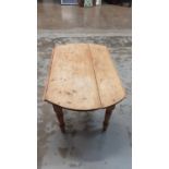 Old pine drop leaf table on turned legs, opening to 128cm x 115cm
