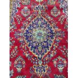 Eastern rug with central medallion on red and blue ground, 338cm x 212cm