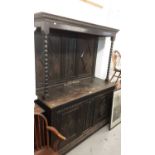 Late Victorian carved oak two height sideboard with panelled back flanked by bobbin turned supports,