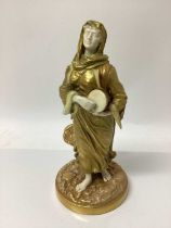 An early 20th century Royal Worcester figure of a musician, modelled in gilt as a lady with a drum,