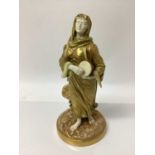 An early 20th century Royal Worcester figure of a musician, modelled in gilt as a lady with a drum,