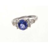 Tanzanite and diamond ring with an oval mixed cut tanzanite flanked by six round brilliant cut diamo