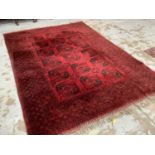 Large Bokhara rug, having three rows of five quartered medallions on claret ground, in geometric bor