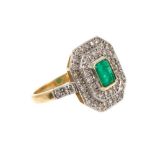 Art Deco emerald and diamond cluster ring with a central rectangular step cut emerald surrounded by