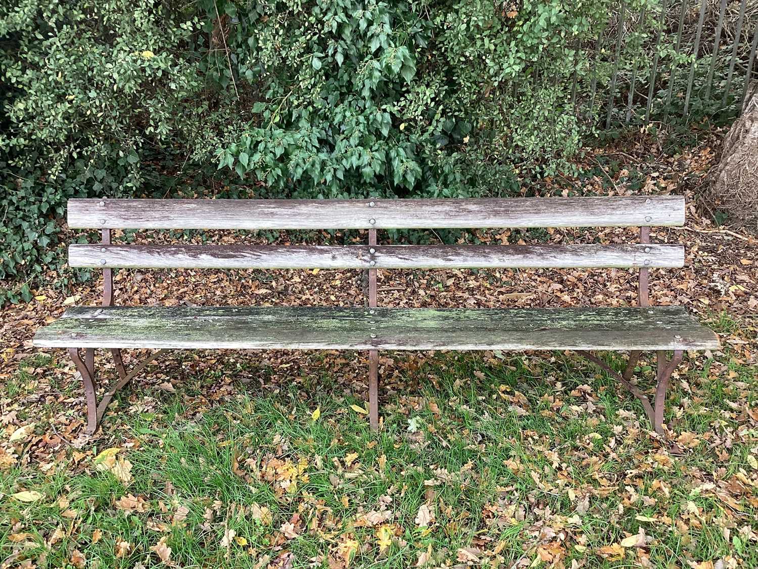 Set of three very long antique slatted and cast iron benches, on scrolled supports, 245cm long