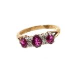 Ruby and diamond ring with three oval mixed cut rubies and four single cut diamonds in gold claw set