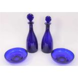 A near pair of 19th century Bristol blue glass decanters with facet-cut stoppers, the larger measuri