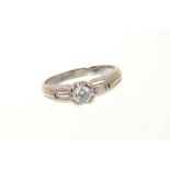 Diamond single stone ring with a brilliant cut diamond flanked by two tapered baguette cut diamonds